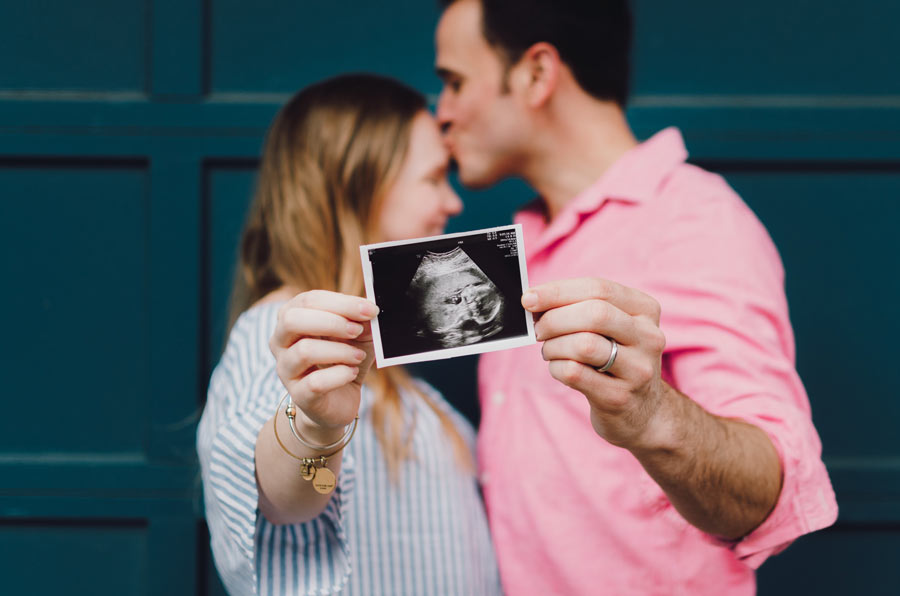 Man and woman holding out an ultrasound photograph