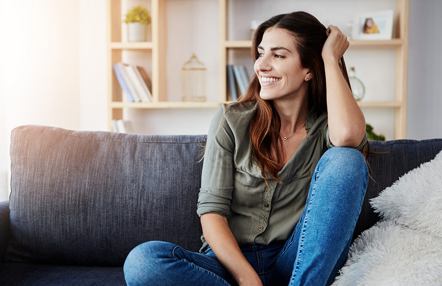 Woman sitting casually on a sofa, smiling